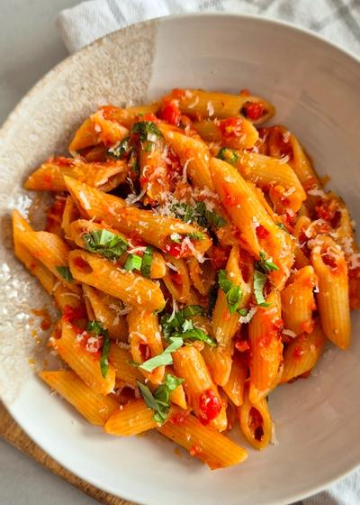 Penne all'Arrabbiata mit scharfer Chili und Perocino auf einem Teller serviert.