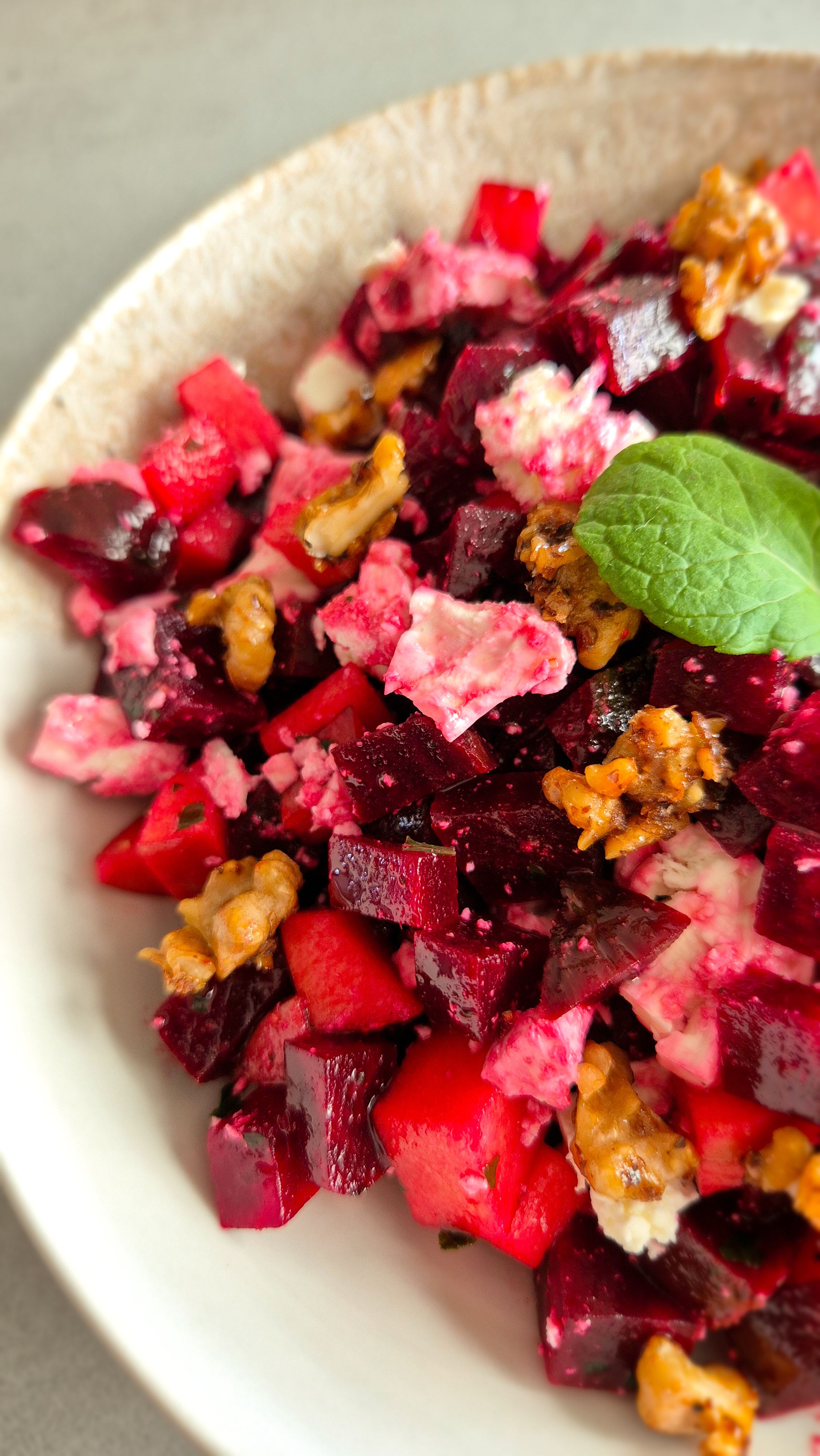 Rote Beete Salat mit Feta, Minze und kandierten Walnüssen in einer Schüssel.