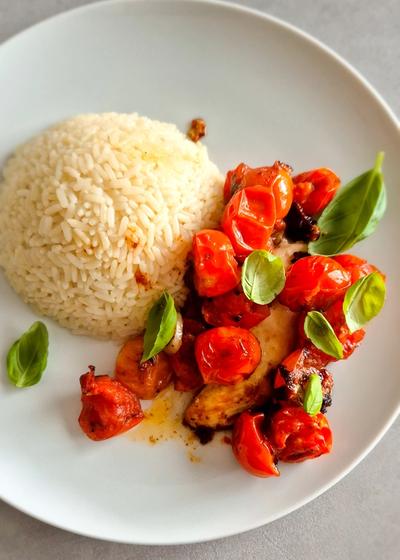 Hähnchen Caprese mit Reis und Basilikum auf einem Teller.