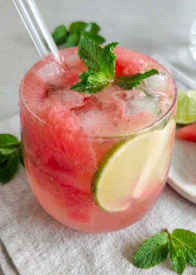 Sommerlicher Mocktail mit Wassermelone, Limette und Minze in einem Glas.