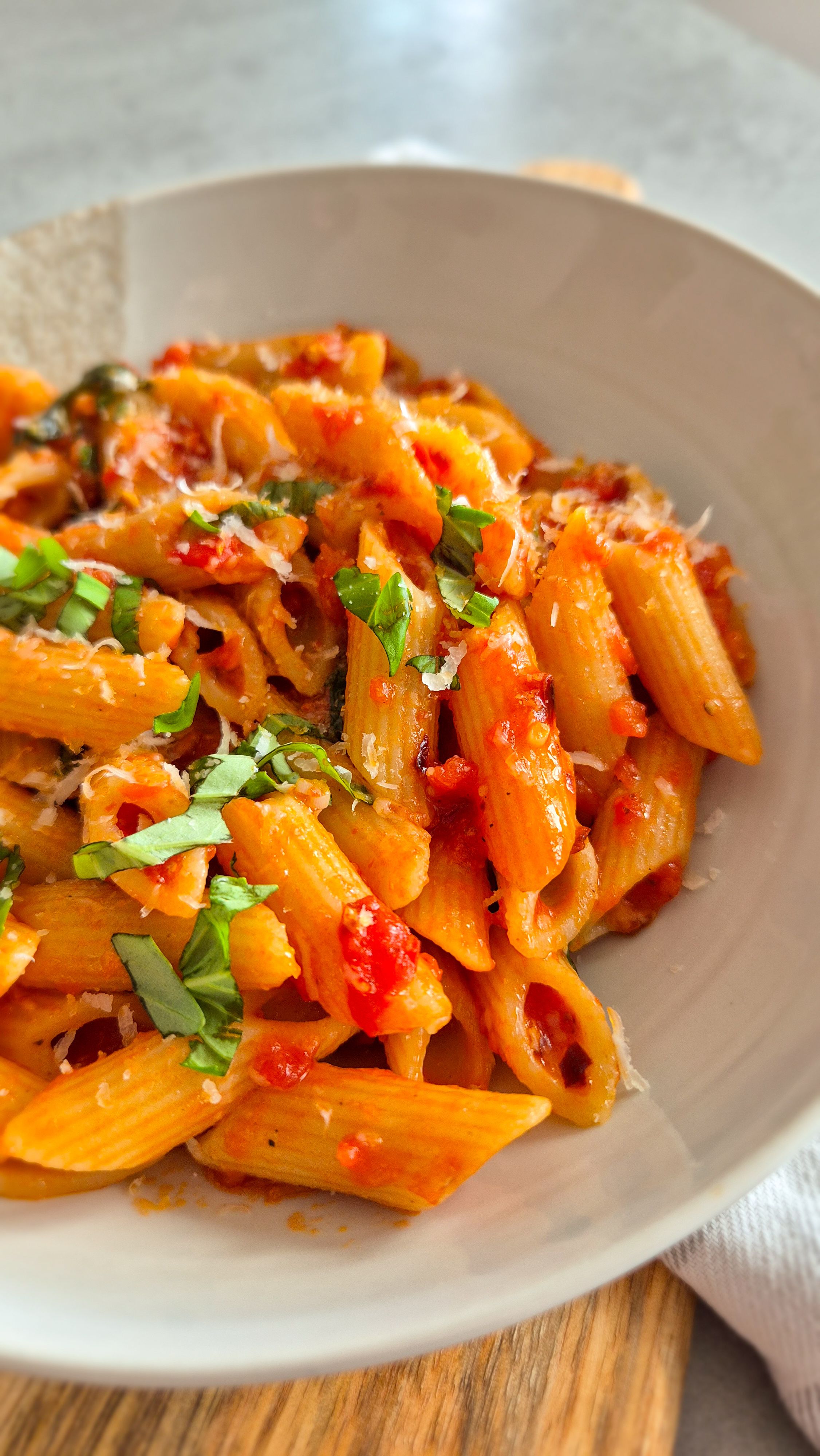 Penne all'Arrabbiata mit scharfer Chili und Perocino auf einem Teller serviert.