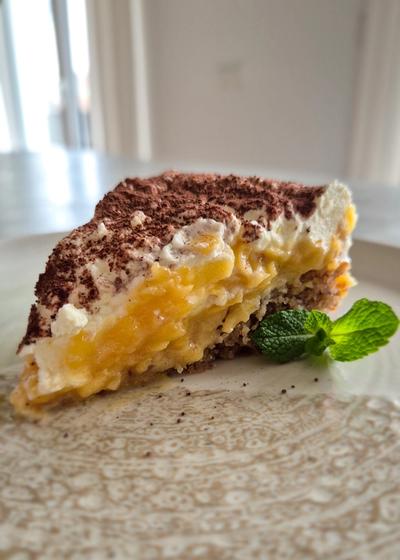 Ein Stück saftige schwedische Apfeltorte mit einer dicken Haube aus Mascarpone-Sahne auf einem Vintage-Teller
