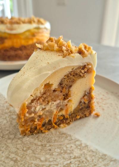 Cremiger Carrot Cake Cheesecake mit leckerem Frosting wie aus den USA auf einem Teller serviert.