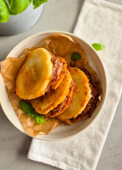Venezolanische Arepas aus P.A.N. Maismehl mit Carne Mechada auf einem Teller.