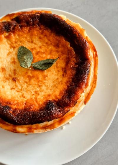 Cremiger San Sebastian Cheesecake mit einer dunkelbraun karamellisierten Kruste auf einem Teller.