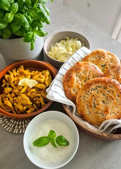 Chicken Shawarma serviert mit Fladenbrot und Beilagen