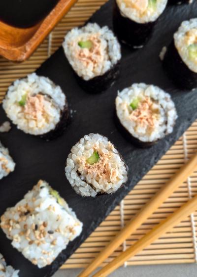 Spircy Tuna Maki Rolls auf einer Schieferplatte zu Sojasauce und Wasabi serviert.