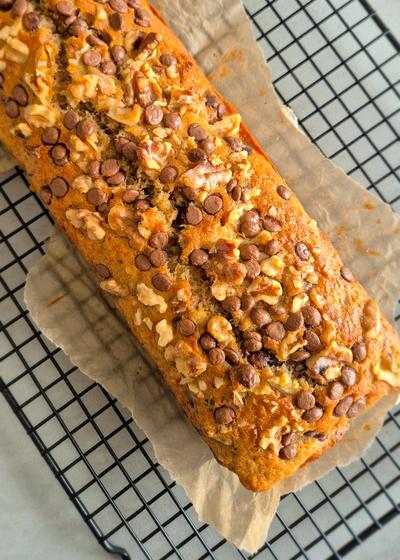 Frisch gebackenes Bananenbrot mit Walnüssen und Schokoladen-Chunks auf einem Rost.