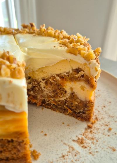 Cremiger Carrot Cake Cheesecake mit leckerem Frosting wie aus den USA auf einem Teller serviert.