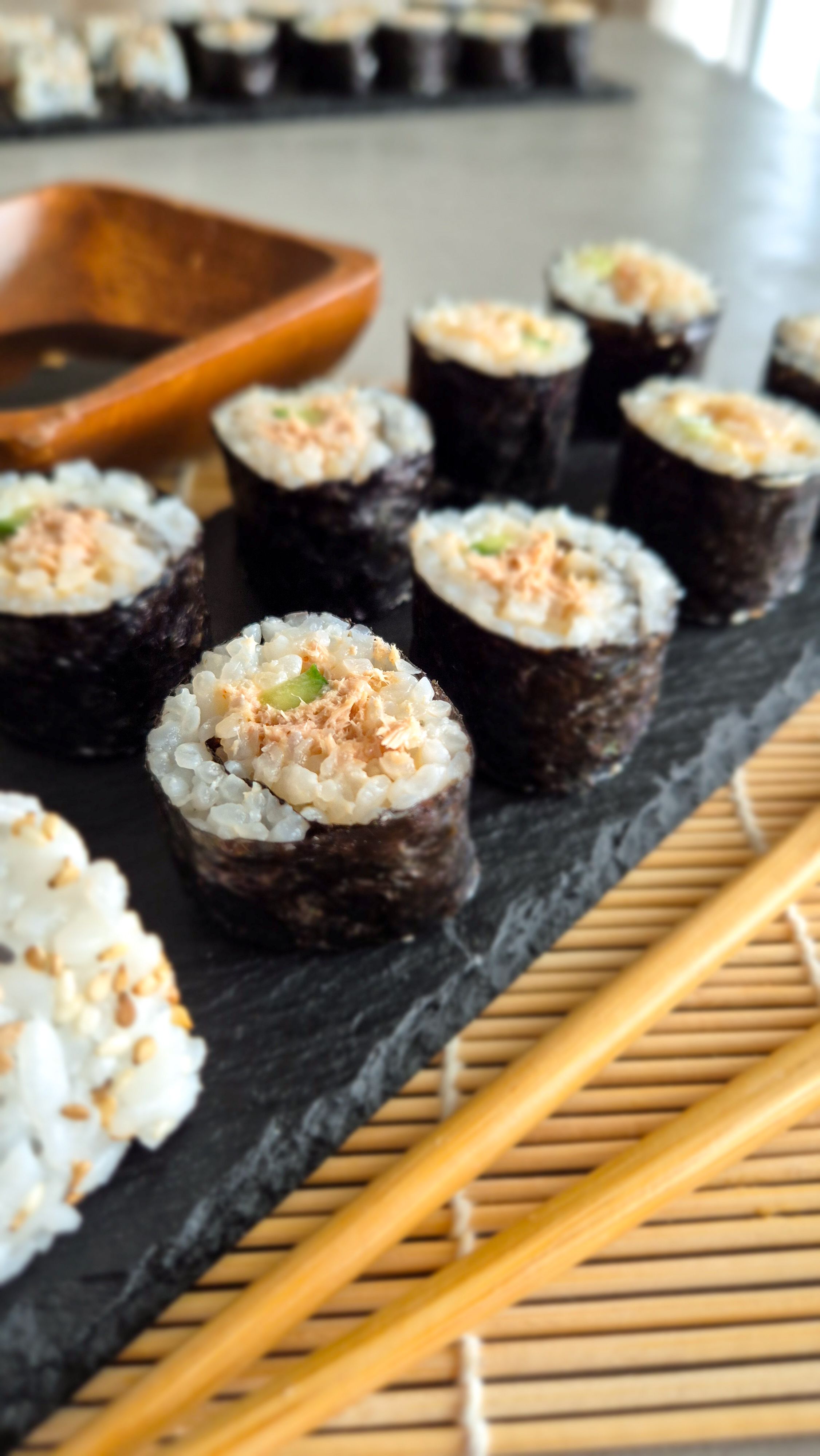 Spicy Surimi und Garnelen Sushi auf einer Schieferplatte serviert.