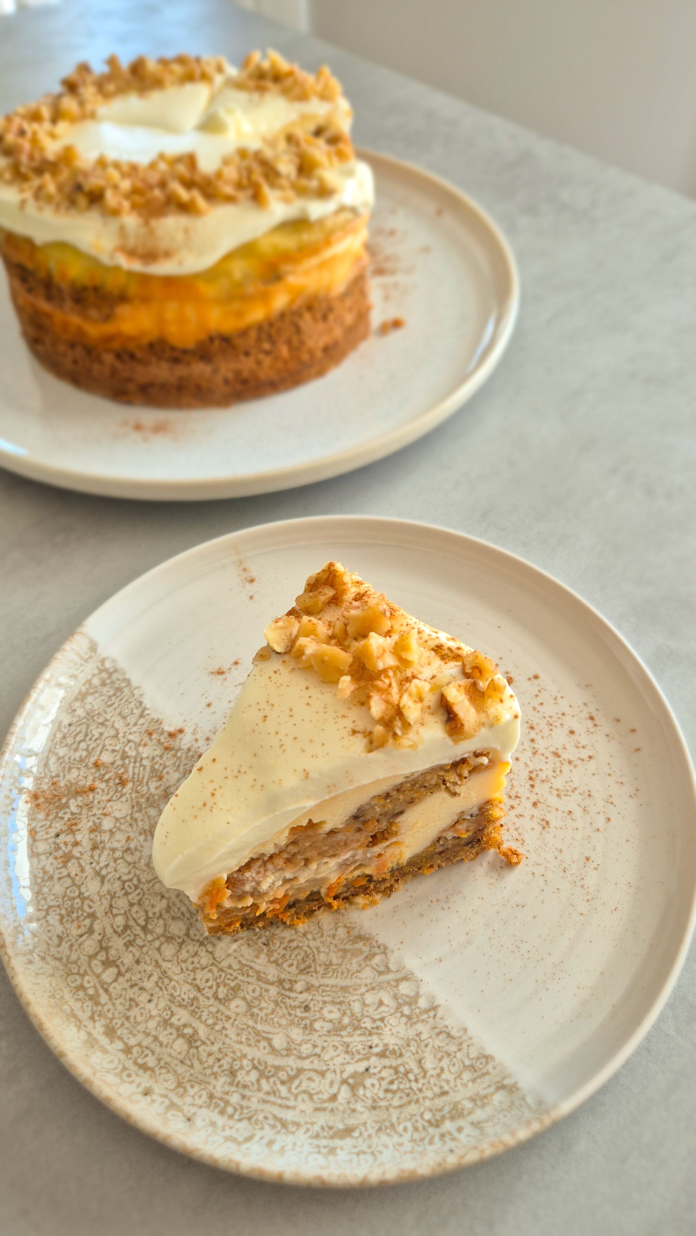 Cremiger Carrot Cake Cheesecake mit leckerem Frosting wie aus den USA auf einem Teller serviert. 