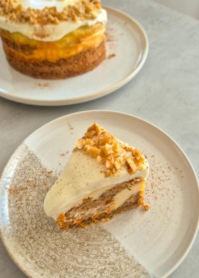 Cremiger Carrot Cake Cheesecake mit leckerem Frosting wie aus den USA auf einem Teller serviert.