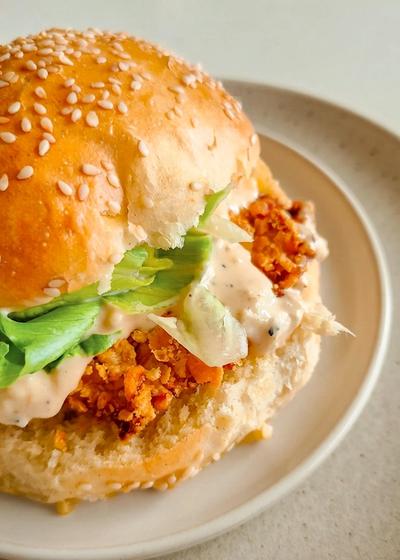 Hausgemachter Caesar Salad Crispy Chicken Burger mir frischem Römersalat und Dressing.