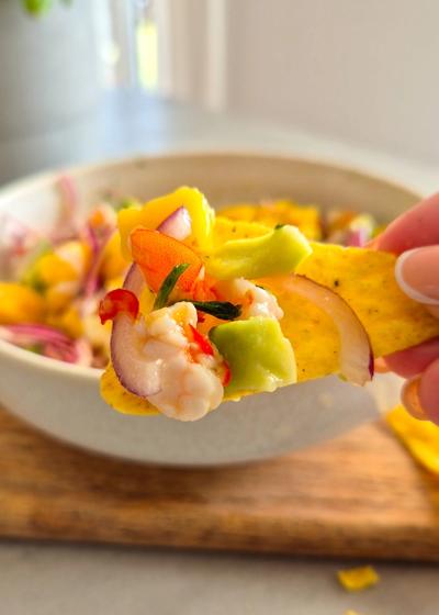 Servierfertiges Garnelen Ceviche mit Mango und Avocado auf einem Tortilla-Chip Nacho