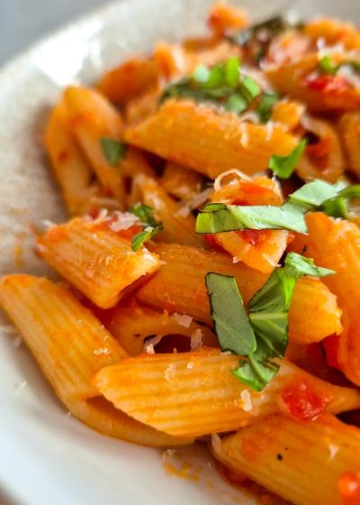 Penne all'Arrabbiata mit scharfer Chili und Perocino auf einem Teller serviert.