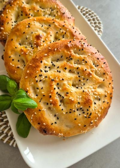 Traditionelles türkisches Fladenbrot mit Sesam und Schwarzkümmel auf einem Teller serviert.