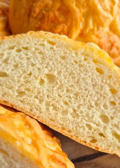 Querschnitt eines fluffigen selbstgebackenen Käsebrötchens.