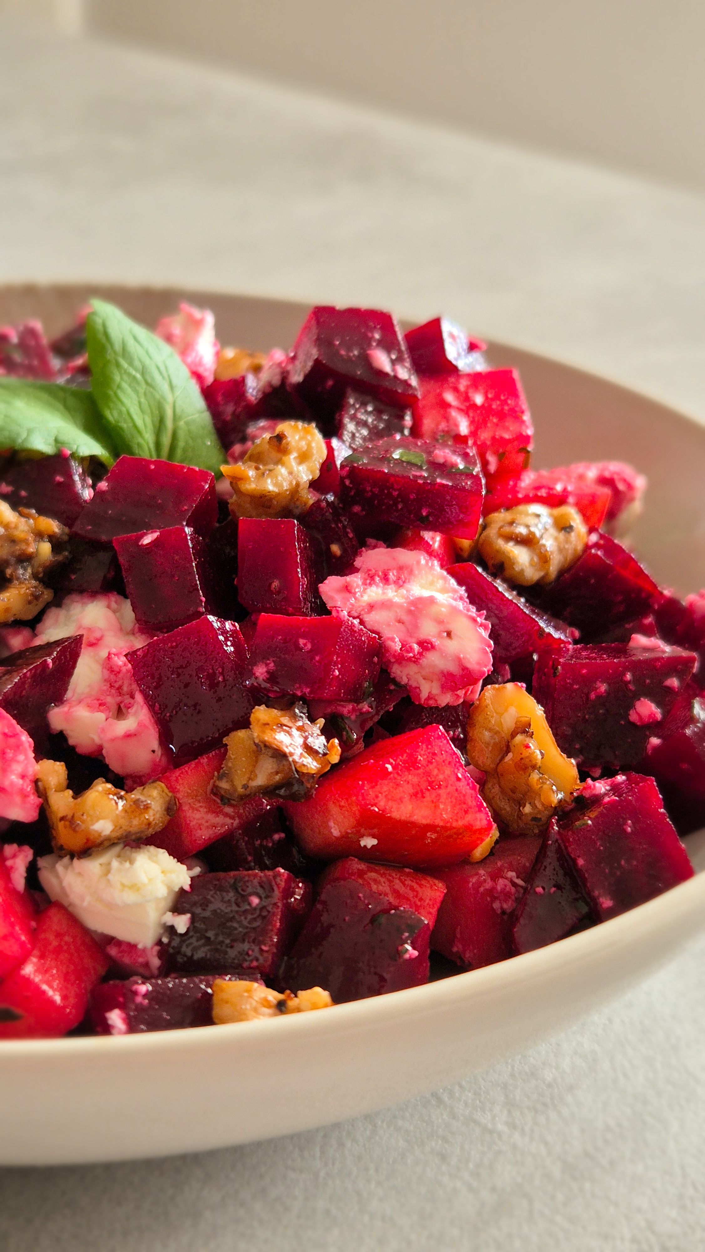 Rote Beete Salat mit Feta, Minze und kandierten Walnüssen in einer Schüssel.