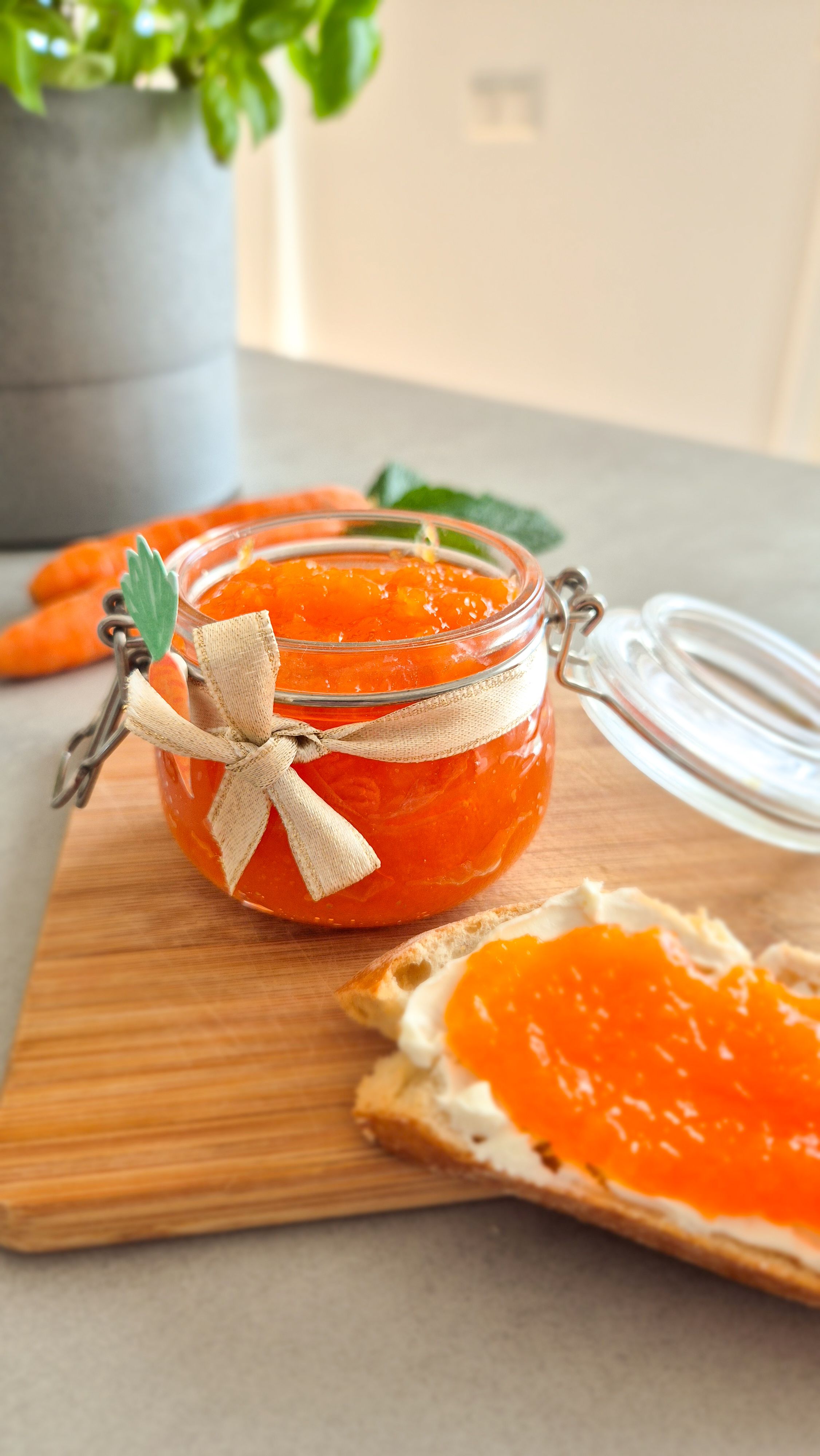 Ein dekorativ angerichtetes Glas Hasenfrühstück (Karotten-Apfel-Marmelade) mit einem Baguette zum Frühstück.