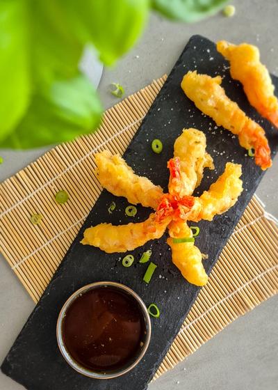 Knusprige Ebi Tempura auf einer Schieferplatte mit einem Dip serviert.