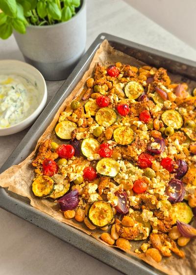 Griechisches Gemüse mit Hähnchen auf einem Blech.