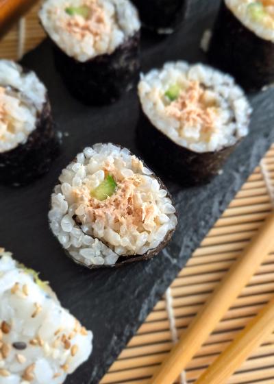 Maki mit Gurke und einer mild-scharfen Tunfisch-Füllung auf einer Platte serviert.