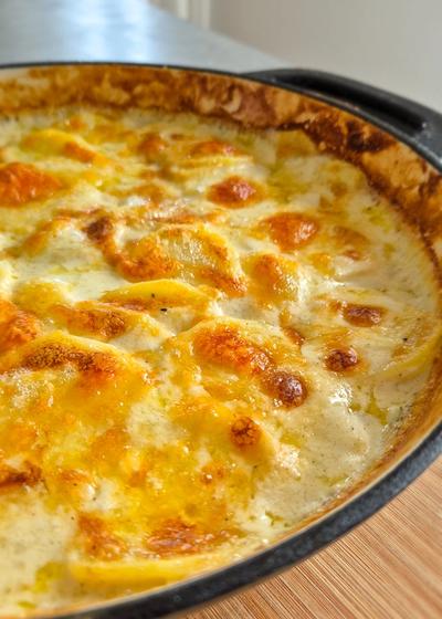 Mit Käse überbackenes cremiges Kartoffelgratin.