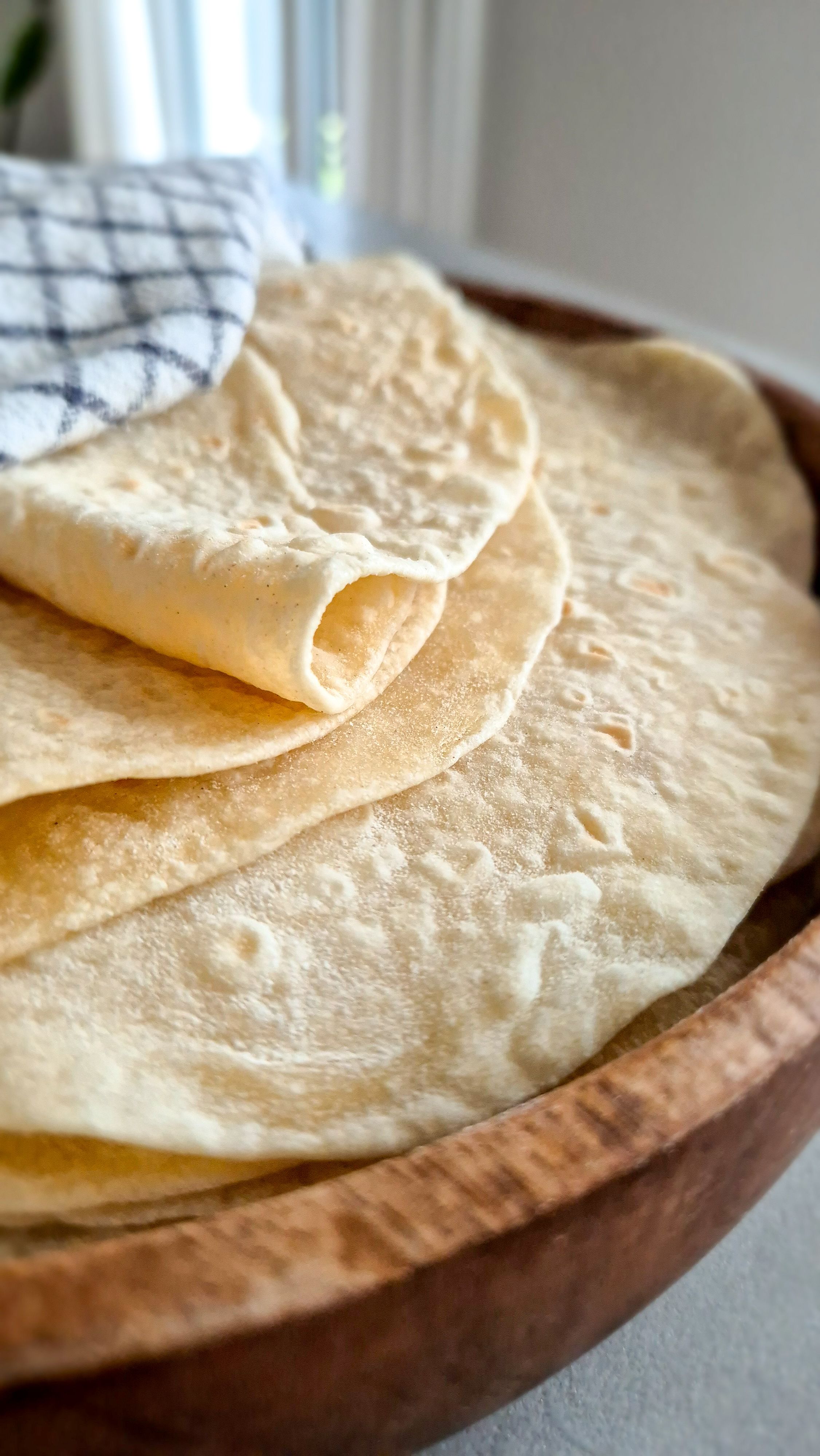 Hausgemachte Weizentortillas wie aus Mexiko - perfekt für Quesadillas, Wraps und Burritos, in ein Tuch gewickelt.