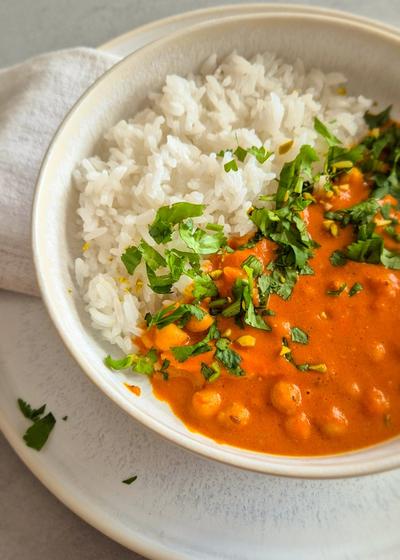 hausgemachtes, würziges Curry nach nordindischer Art in einer Schale mit Koriander serviert.