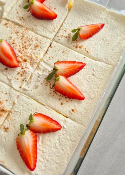 Eine Backform mit Tres Leches Kuchen (in Milch getränkter Kuchen) aus Laterinamerika und frischen Erdbeeren.