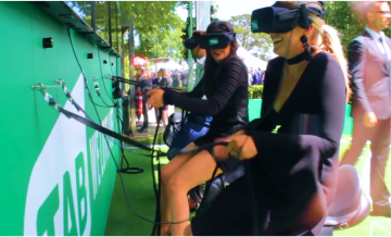 A group of several people at a live VR event playing a horse racing game. 