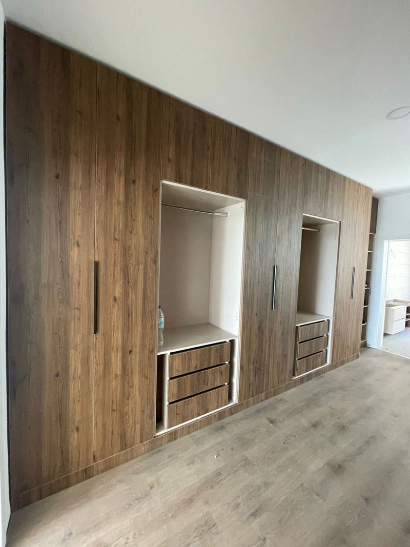 Open closet bay showing hanging rail, shelf, and drawers
