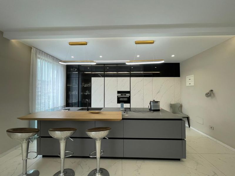Custom kitchen with island and marble cabinet wall