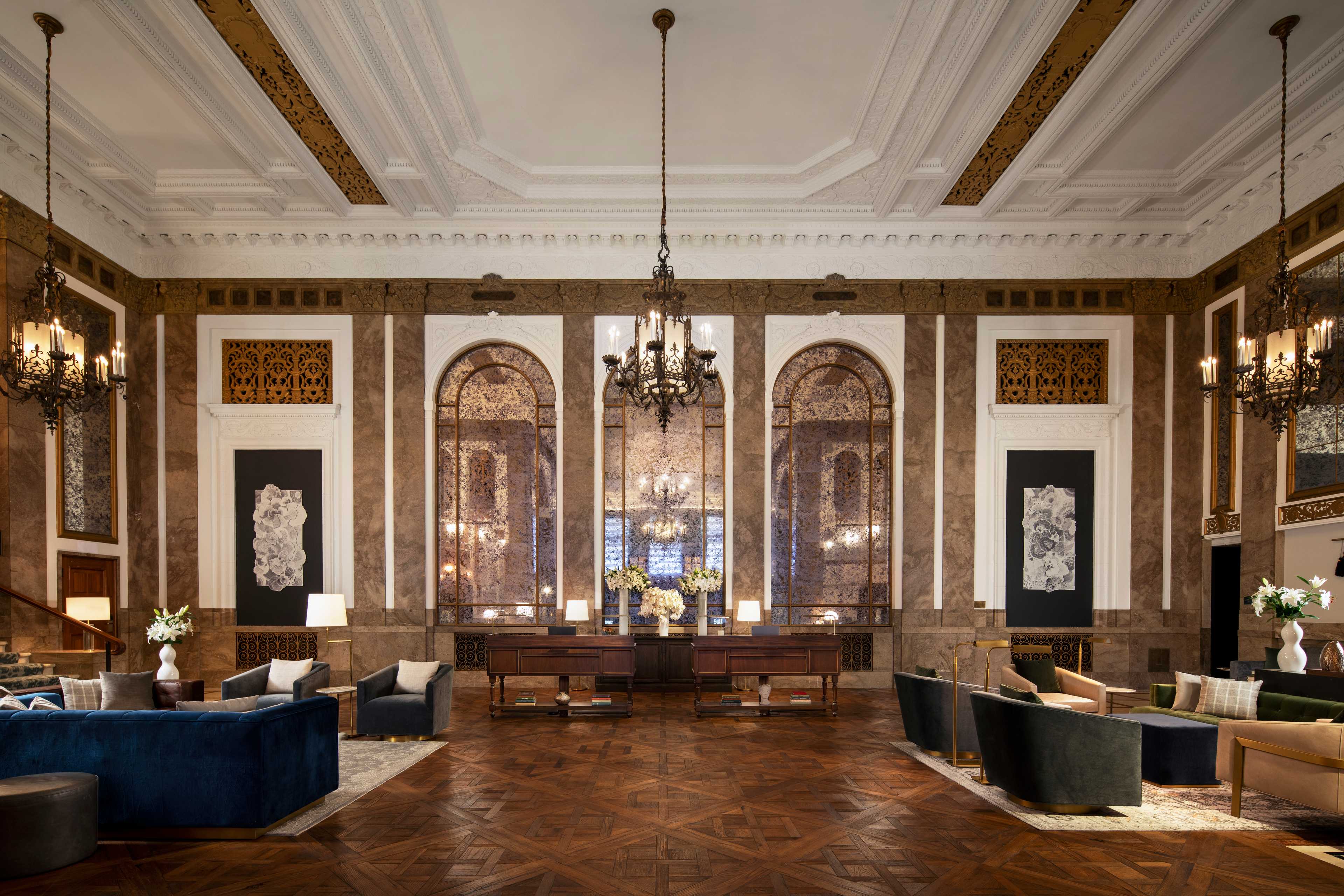 the lobby of a hotel with ornate ceilings and chandeliers.
