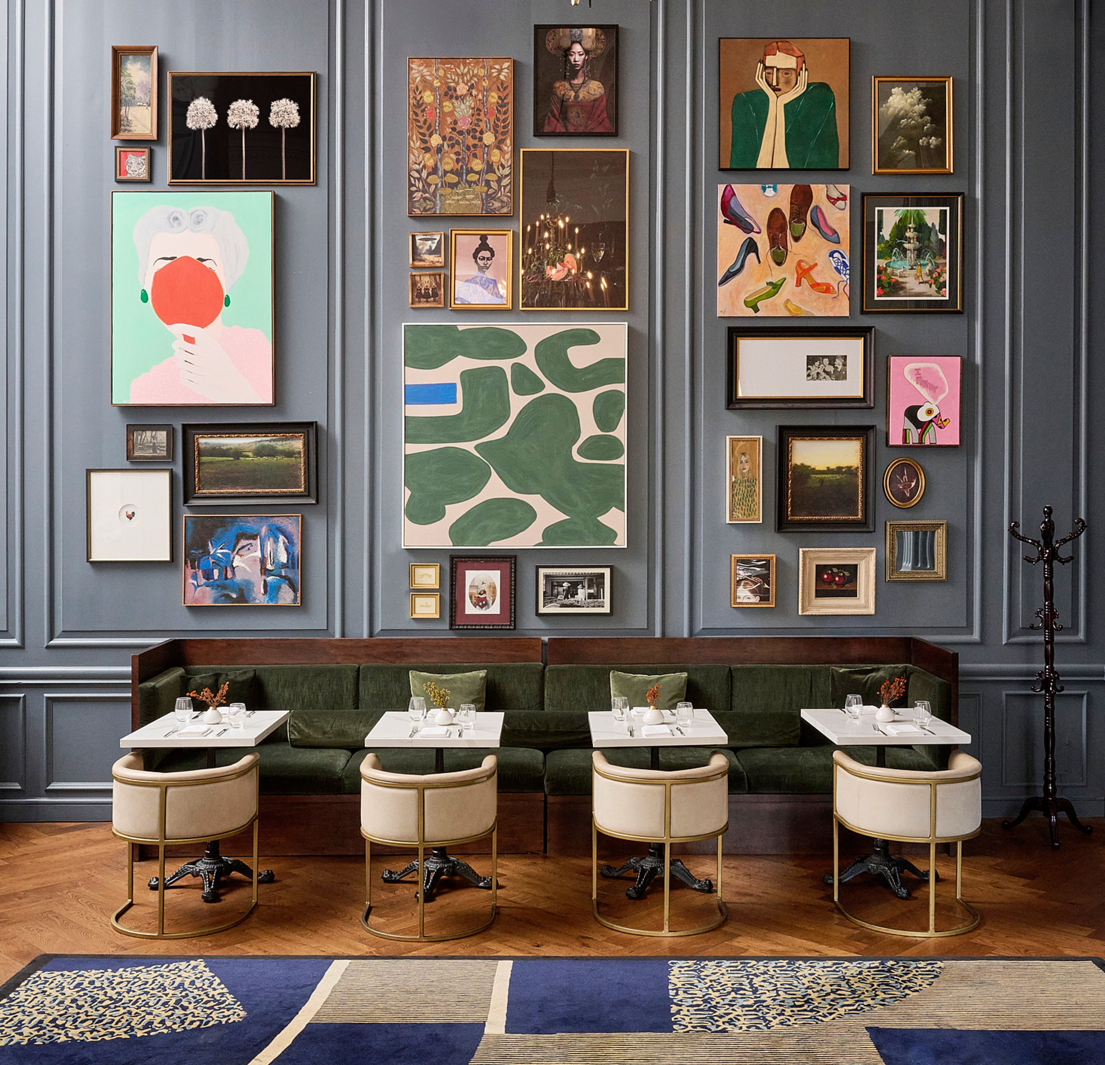 a large dining room with blue walls and artwork.