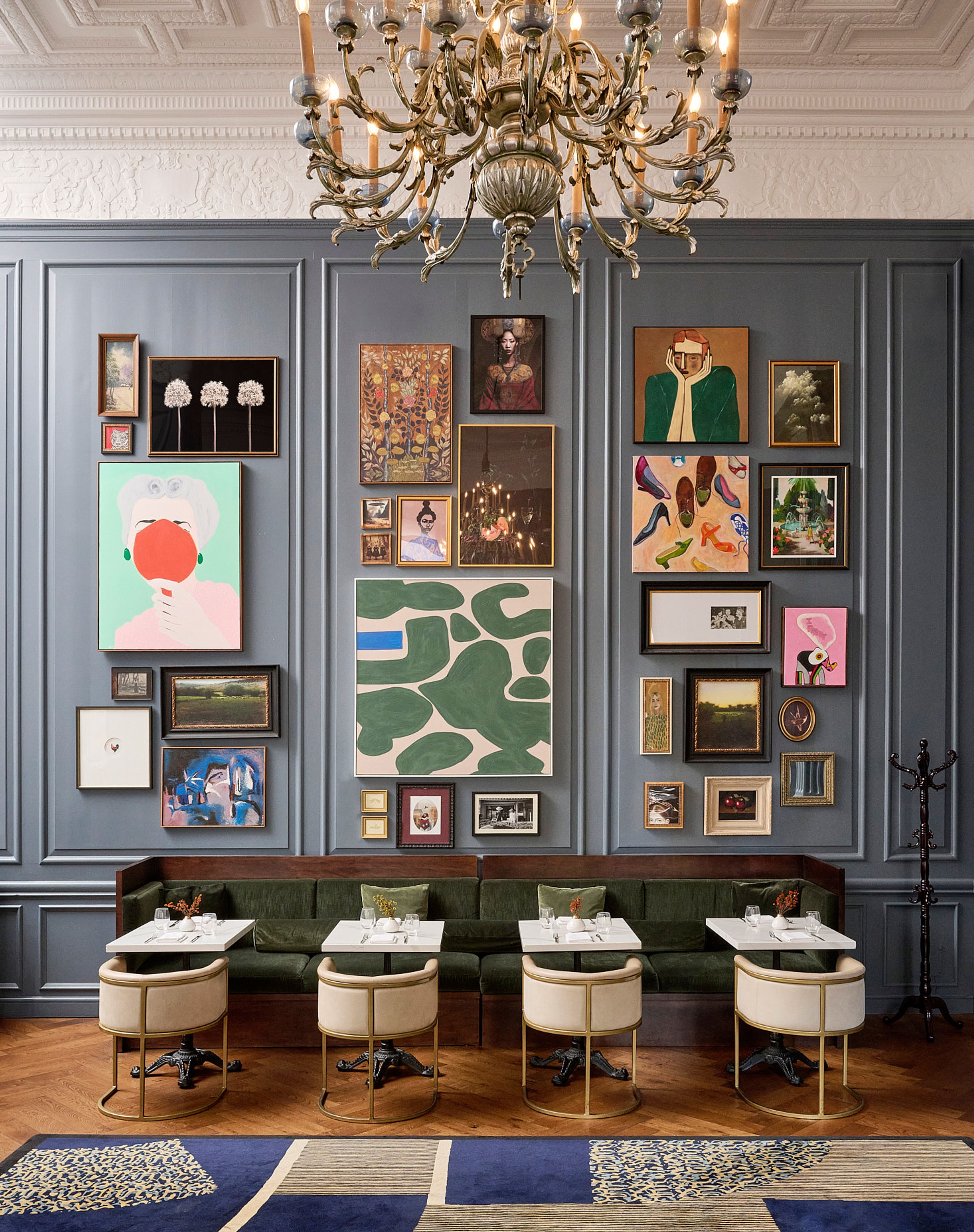a large dining room with blue walls and artwork.