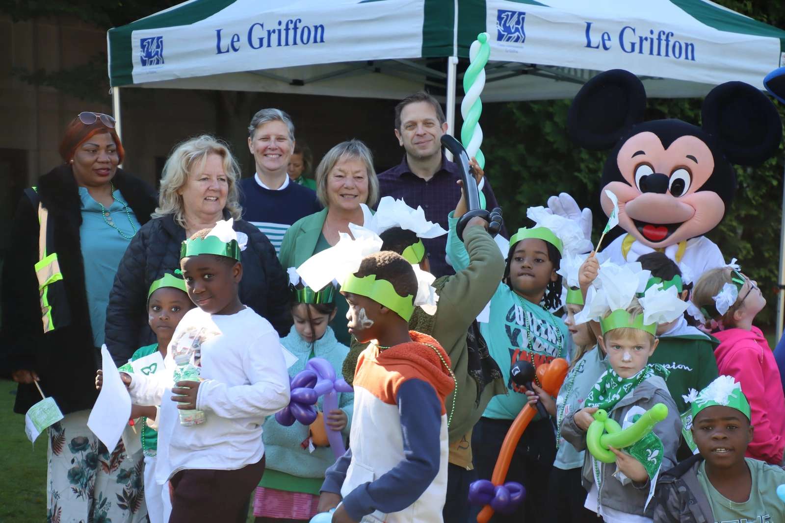Enfants et dignitaires devant la tente du Griffon, avec Mickey en arrière-plan