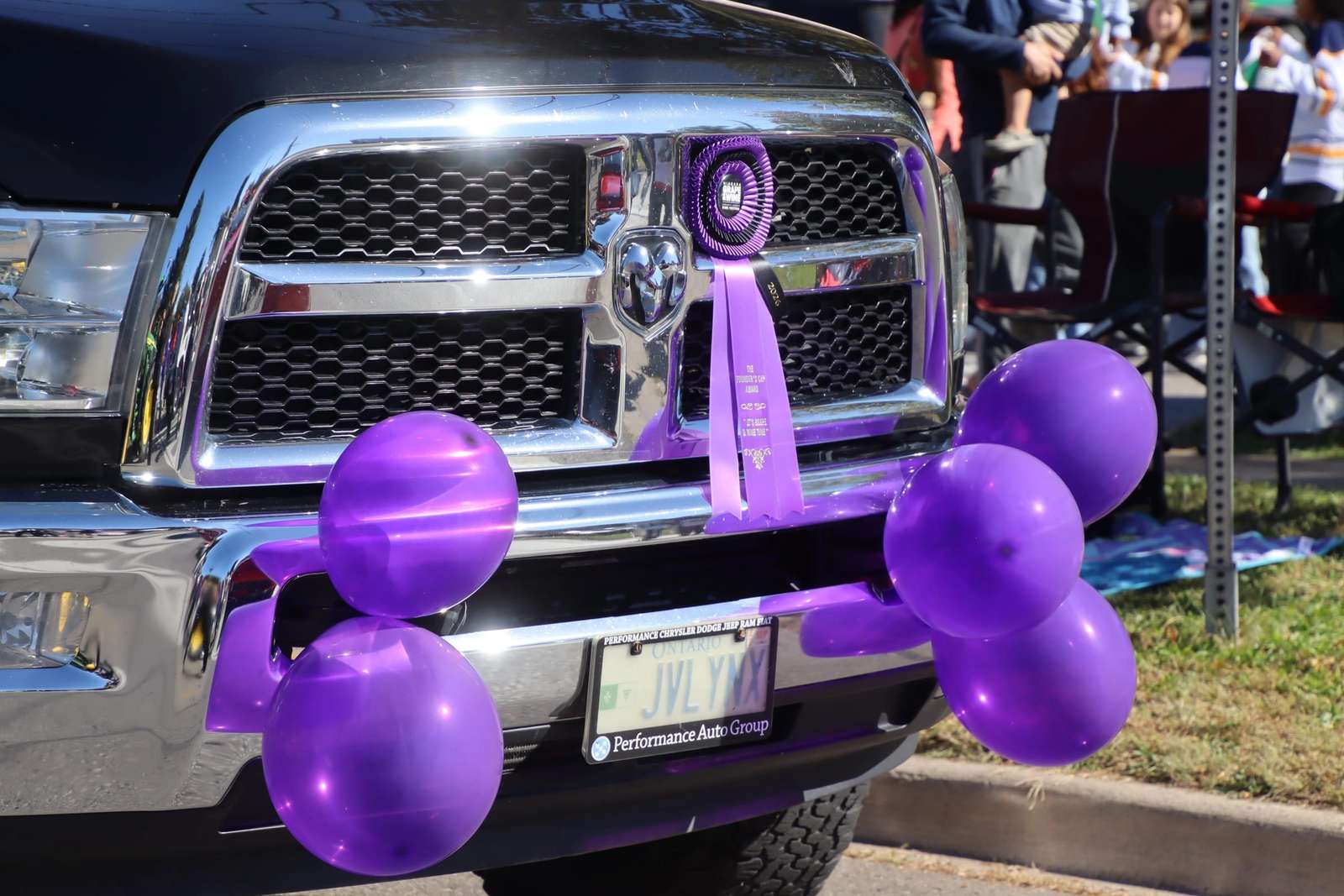 Ruban mauve sur la calandre d’un camion décoré de ballons