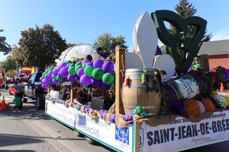 Char de l’école Saint-Jean-de-Brébeuf décoré de ballons mauves et verts dans le défilé
