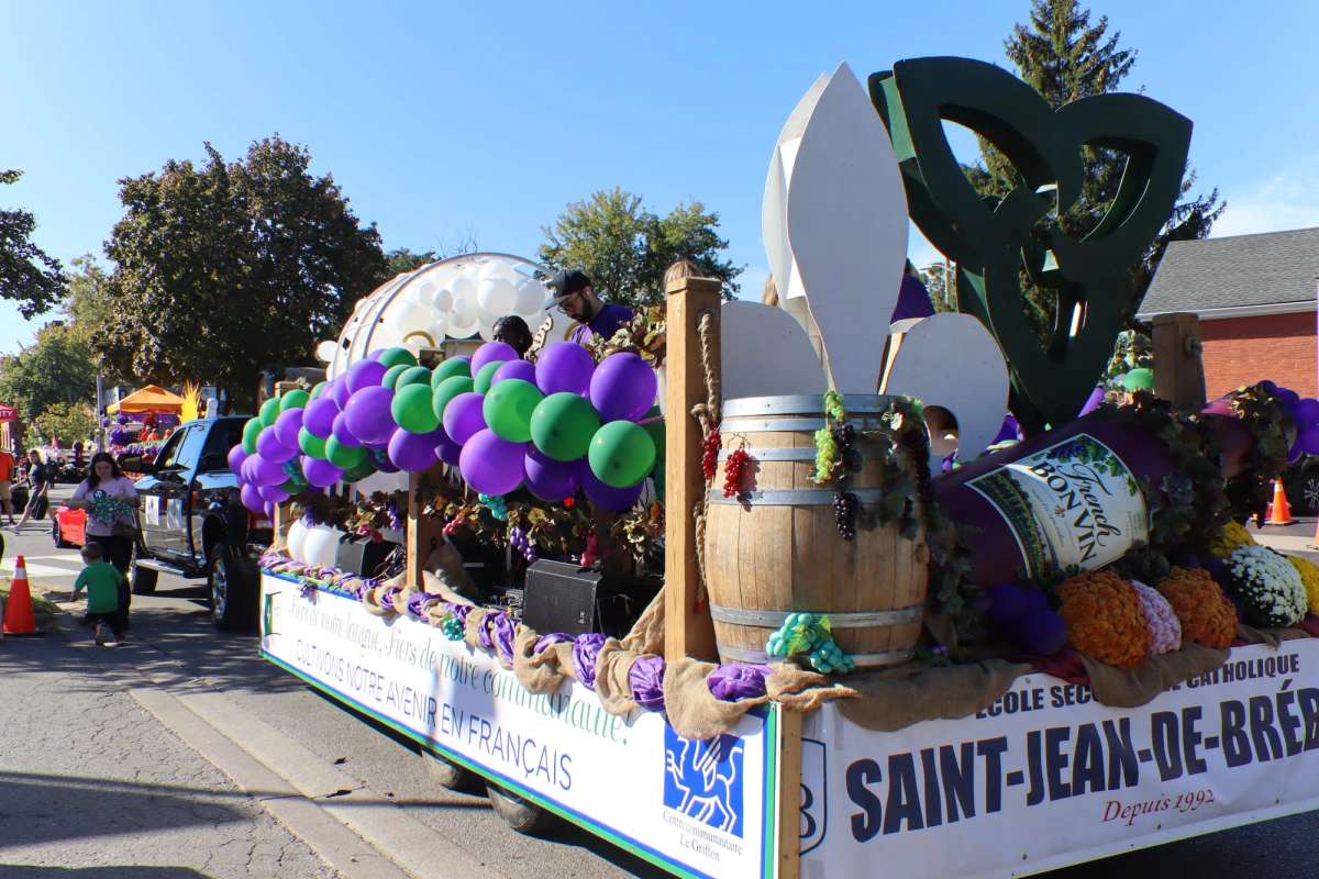 Char de l’école Saint-Jean-de-Brébeuf décoré de ballons mauves et verts dans le défilé