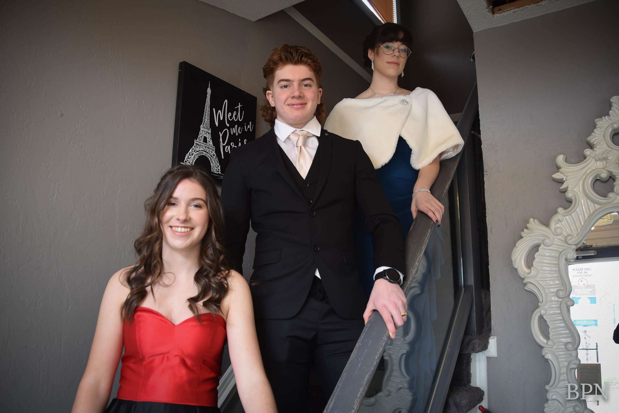 Les trois candidats, habillés aux neufs, debout sur les escaliers.