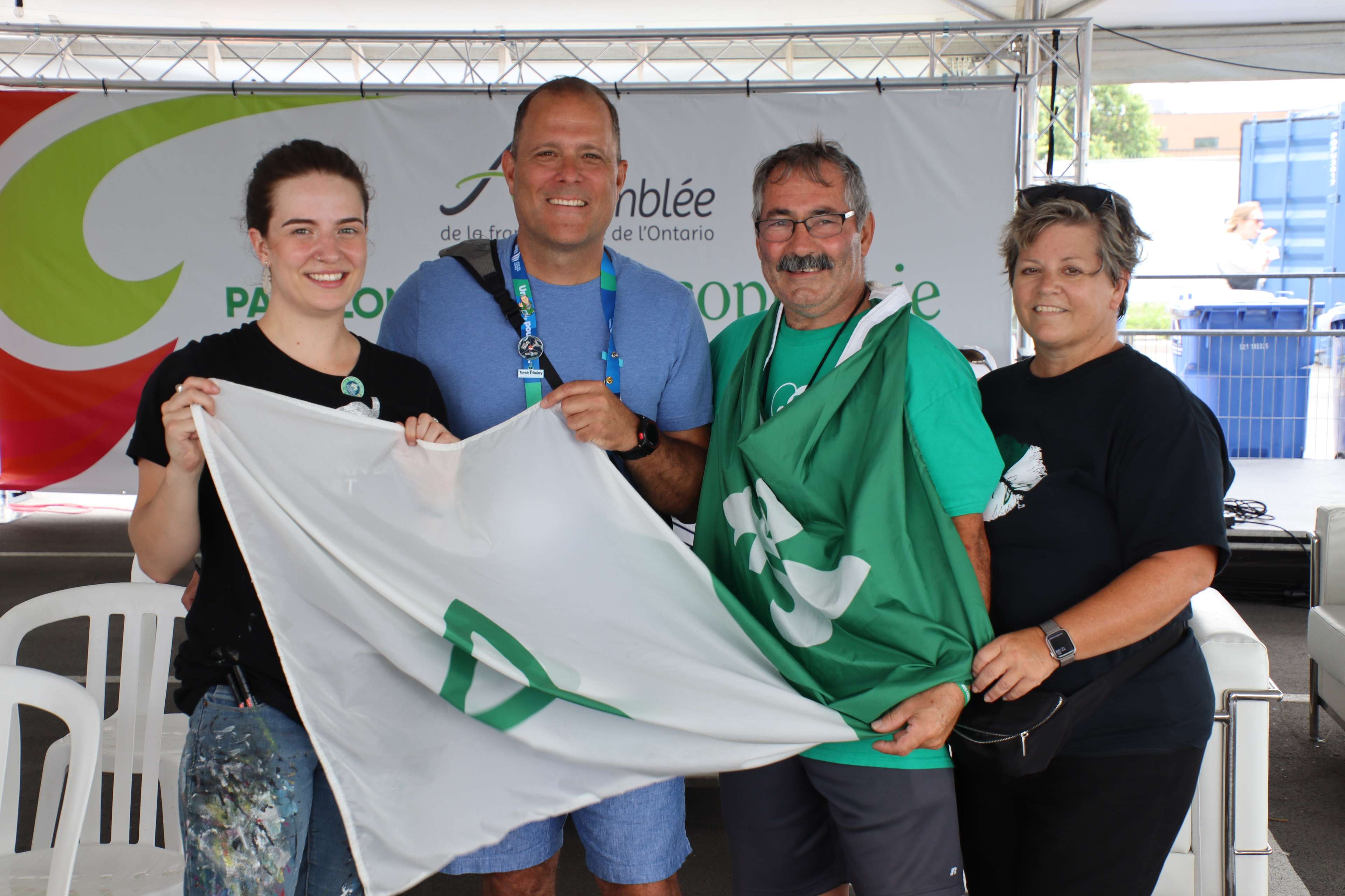 Andréa Letourneau, Walter Sendzik, Jean Chartrand et Mélinda Chartrand avec le drapeau francophone au pavillon de la francophonie