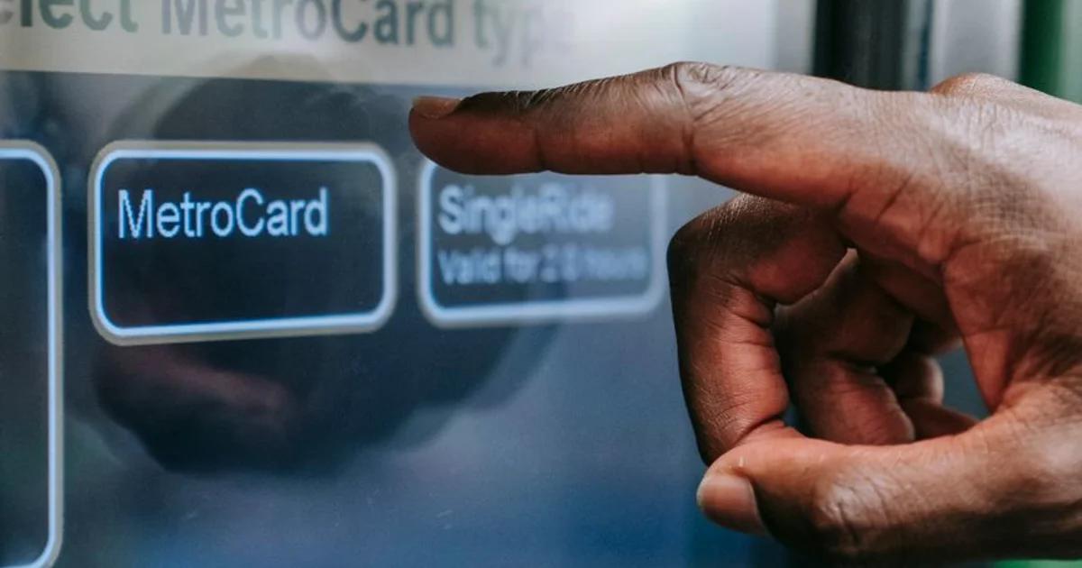 A person using an accessible civic digital wayfinding system kiosk in a city plaza