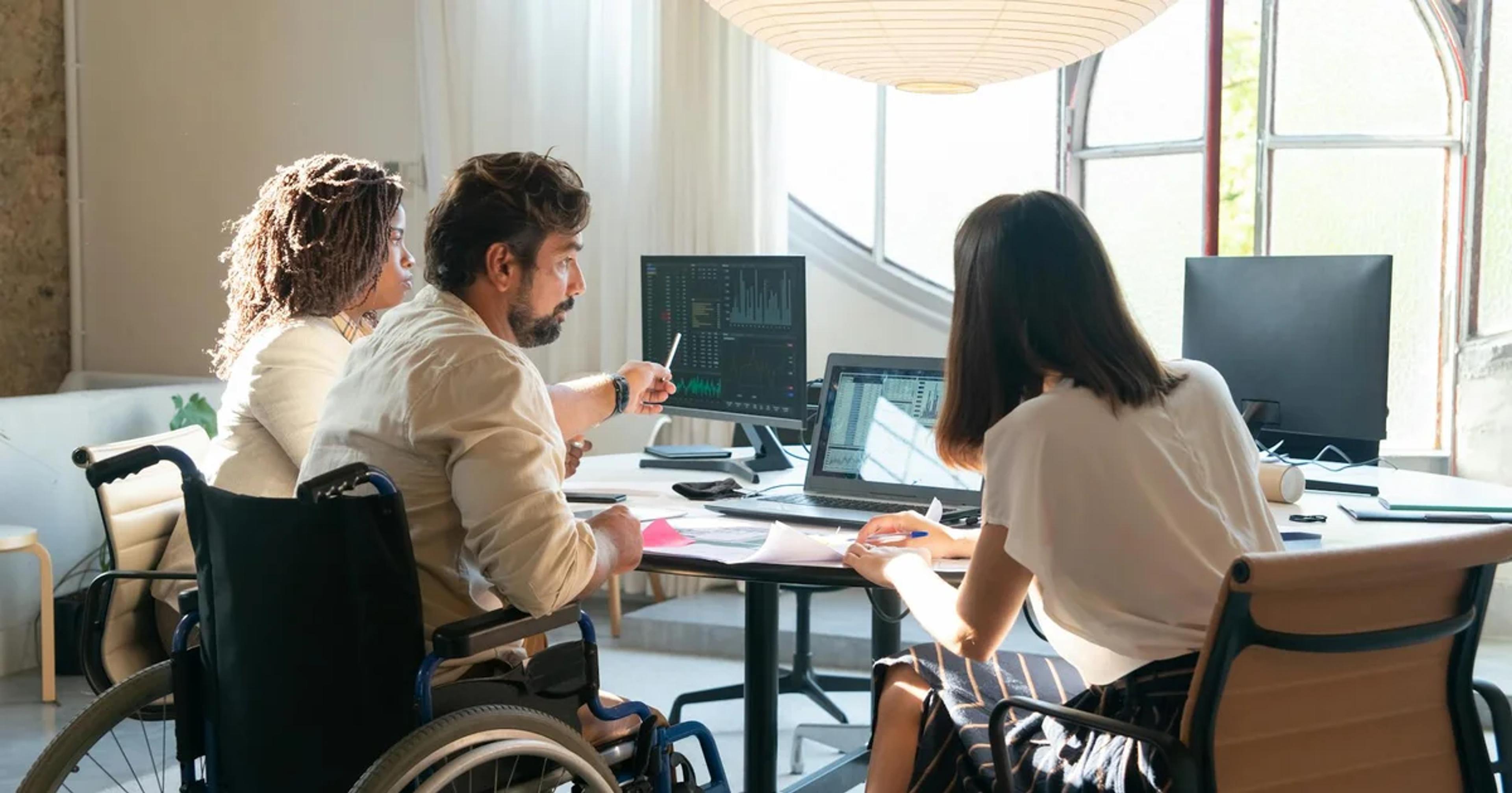 A diverse business team collaborates on a digital strategy, emphasizing effective Distributed Accessibility Governance Models.