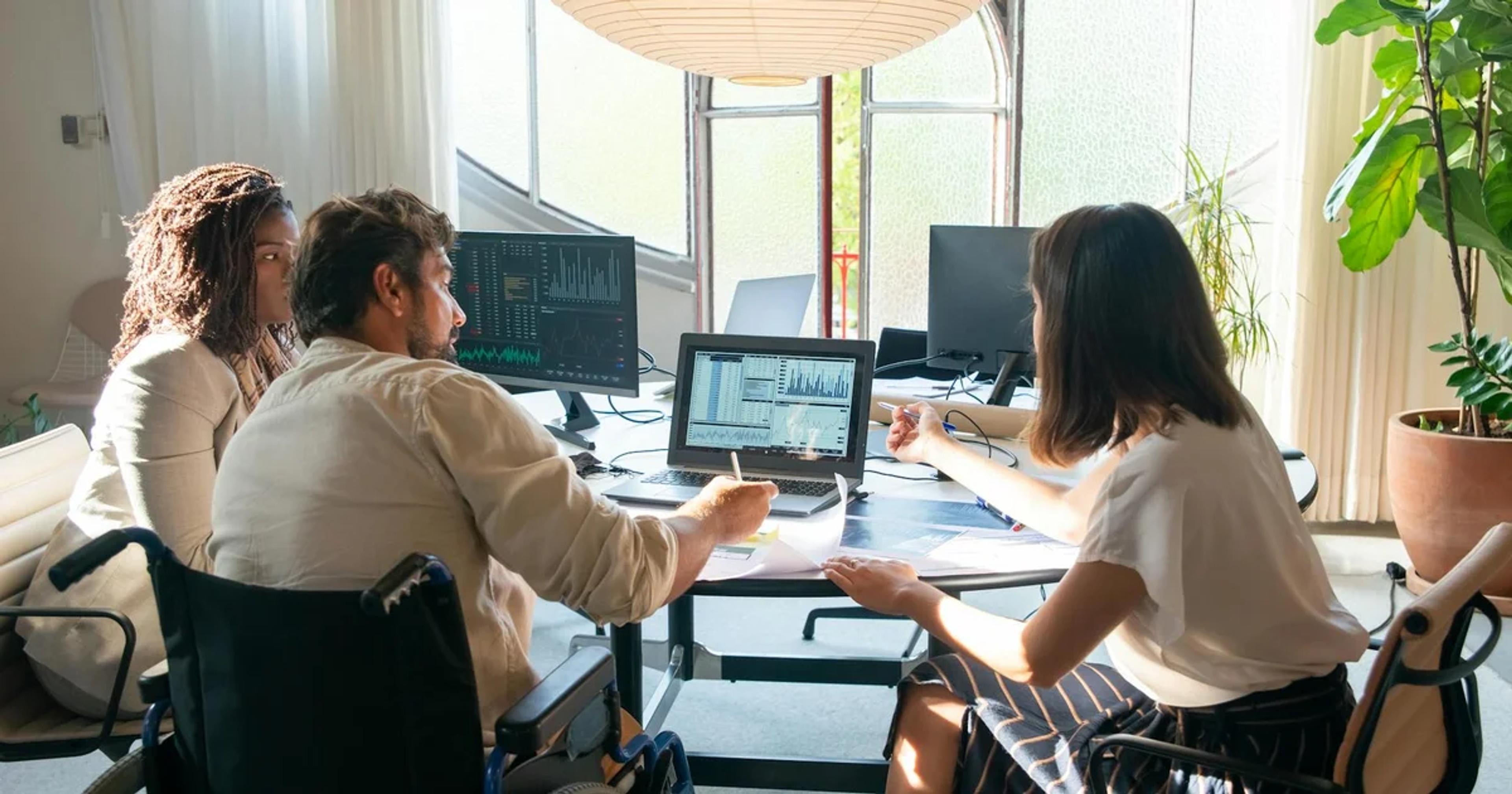 A professional team reviewing digital accessibility data on a shared dashboard.