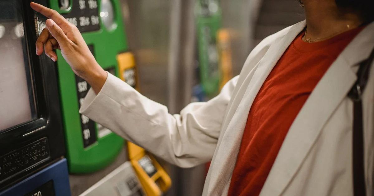 A person using a digital accessible kiosk for ADA compliance in public transit