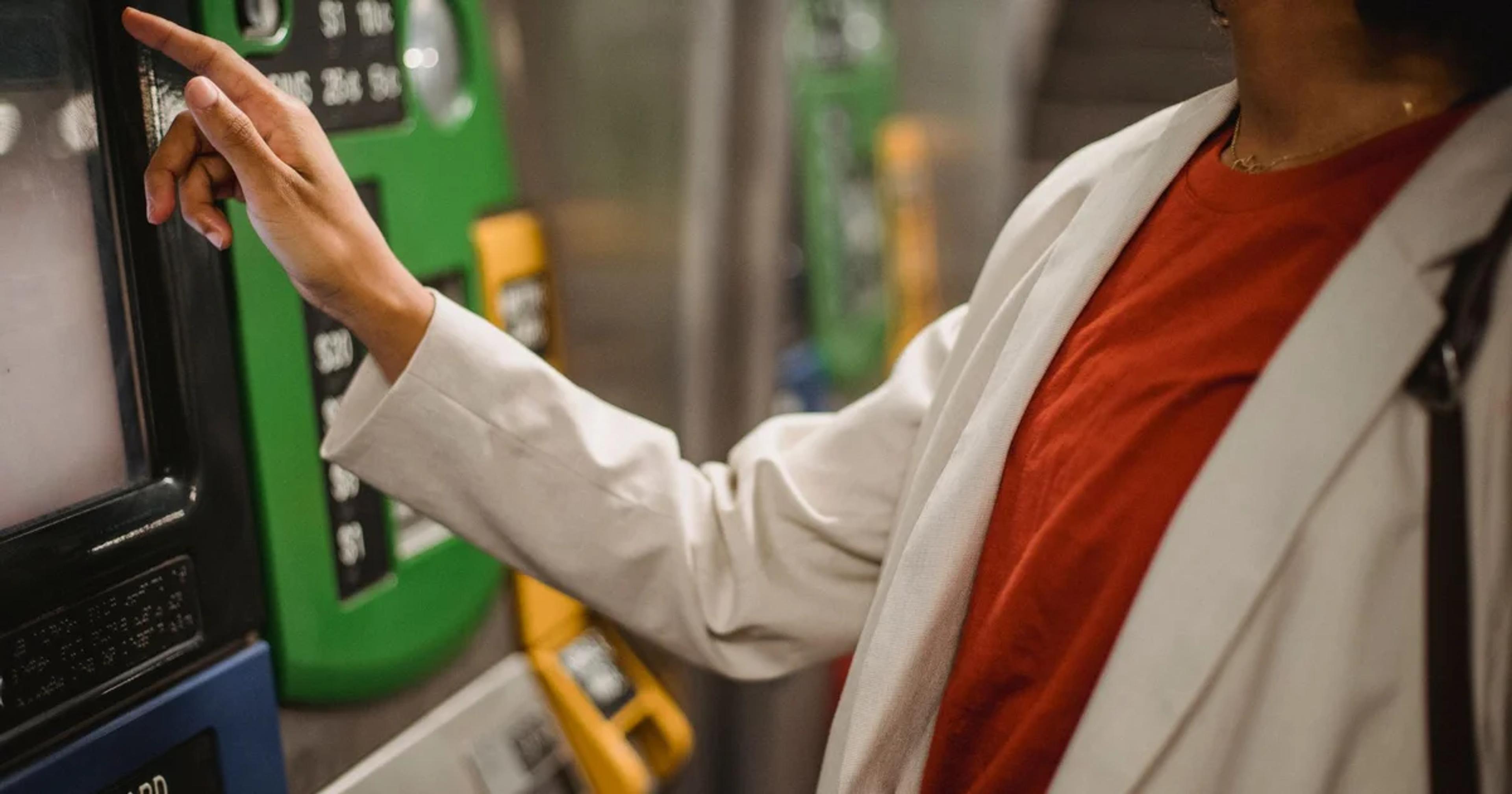 A person using a digital accessible kiosk for ADA compliance in public transit