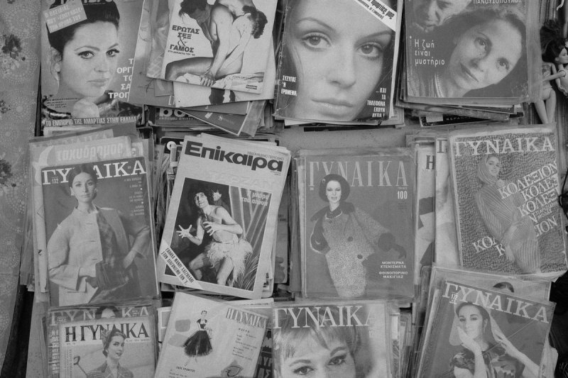 A rack of old Greek magazines, women's faces on every cover. Elaionas, photograph by Yannis Papanastasopoulos