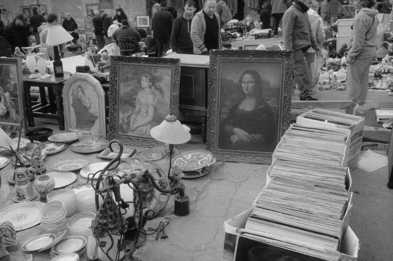 Framed paintings propped on the ground, a copy of the Mona Lisa among them, crates of records beside. Elaionas, photograph by Yannis Papanastasopoulos