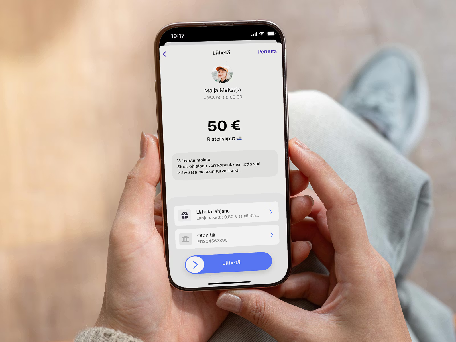 Person holding a smartphone displaying a mobile payment app with a 50€ transaction for "Cruise tickets" to "Maija Maksaja."